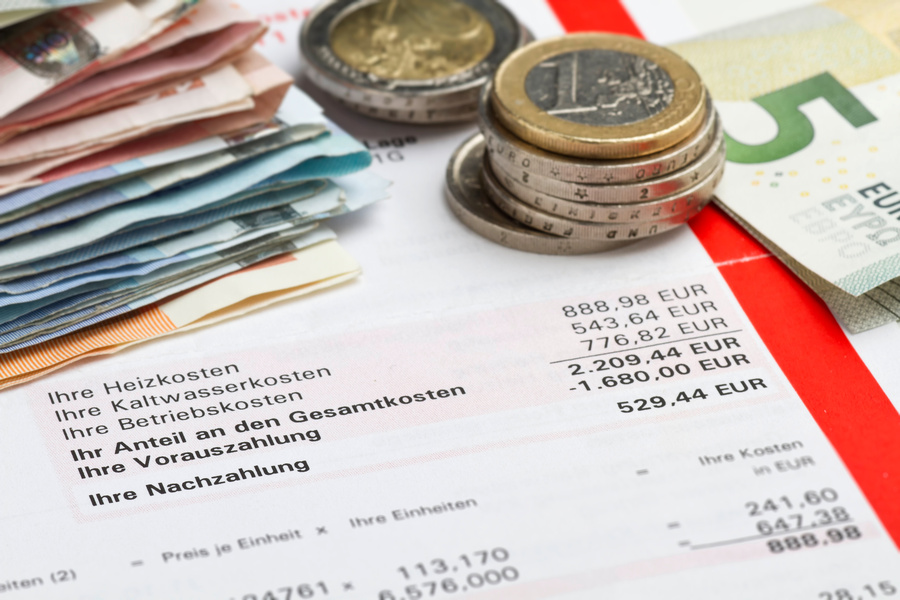 Nebenkostenabrechnung mit Nachzahlung und Münzen